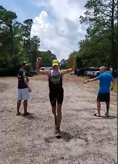 Finishing Half Ironman with arms raised